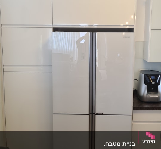 מטבח עם מקרר לבן ומכונת קפה על השיש